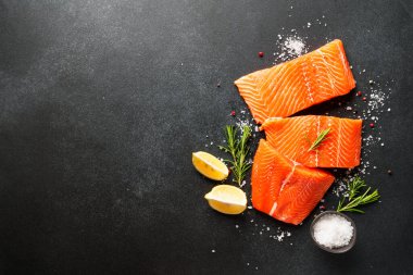 Baharatlı çiğ somon filetosu. Siyah arkaplanda üst görünüm.