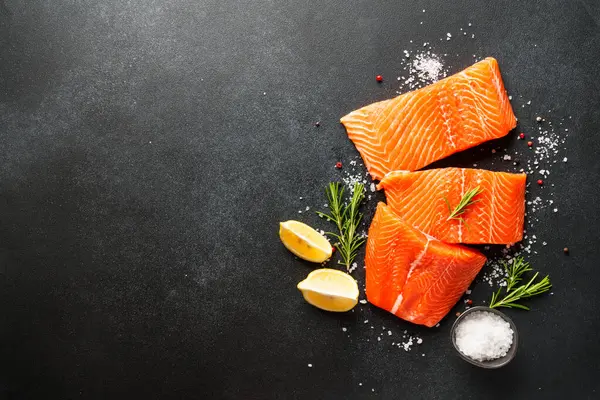 Baharatlı çiğ somon filetosu. Siyah arkaplanda üst görünüm.