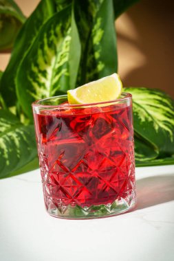 Viski, nar şurubu, acı, limon ve buzlu New Yorker kırmızı kokteyli..