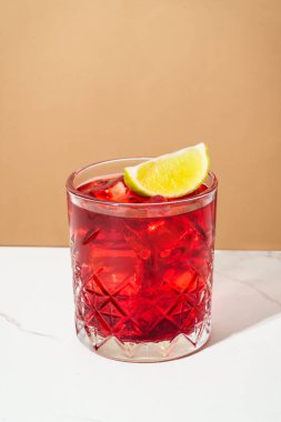 Sert alkol kokteyli. Viski, nar şurubu, acı, kireç ve buz rengi arka planı olan New Yorklu..