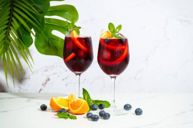 Yaz alkolü, meyve kokteyli. Taze meyveli sangria ve beyaz arka planda buz..