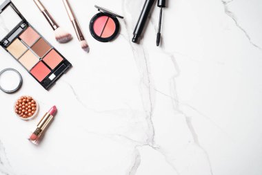 Beyaz arka planda kozmetik ürünleri uydur. Kozmetik palet, fırça, bronzlaştırıcı ve ruj. Düz yatıyordu.