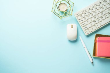 Klavyeli ofis masası, mavi arka planda defter ve kalem. Kopyalama alanı olan düz.