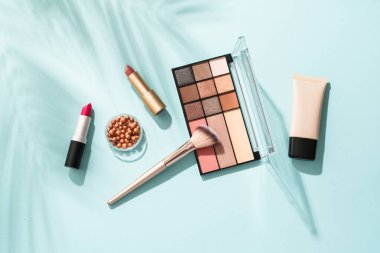 Mavi arka planda profesyonel makyaj ürünleri. Düz yatıyordu.