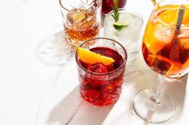 Alkol partisi. Beyaz arka planda sert gölgeli farklı kokteyller..