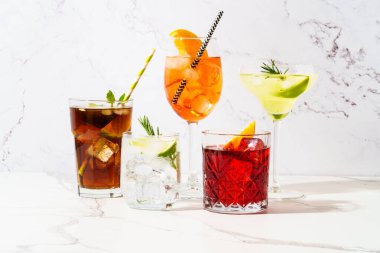 Beyaz arka planda alkollü kokteyl içecekler. Aperol spritz, negroni, Margarita, Küba libre ve jin tonik. Güneşli arkaplan.