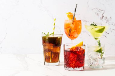 Beyaz arka planda alkollü kokteyl içecekler. Aperol spritz, negroni, Margarita, Küba libre ve jin tonik. Güneşli beyaz arkaplan.