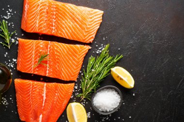 Baharatlı çiğ somon filetosu. Siyah arkaplanda üst görünüm.