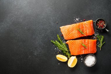Baharatlı çiğ somon filetosu. Siyah arkaplanda üst görünüm.