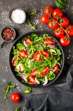 Yapraklı ve sebzeli taze salata. Üst görünüm siyah, dizayn için boşluk.