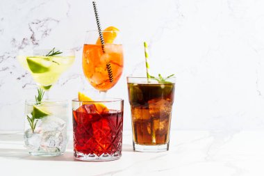 Beyaz arka planda alkollü kokteyl içecekler. Aperol spritz, negroni, Margarita, Küba libre ve jin tonik. Güneşli beyaz arkaplan.