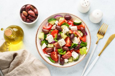 Beyaz masada zeytinli Yunan salatası. Taze sebze, peynir ve zeytinyağı. Düz yatıyordu