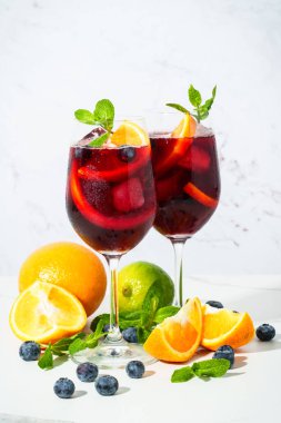 Yaz alkolü, meyve kokteyli. Taze meyveli sangria ve beyaz arka planda buz..