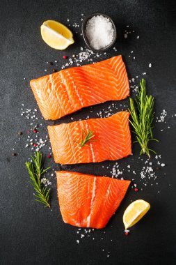 Baharatlı çiğ somon filetosu. Siyah arkaplanda üst görünüm.
