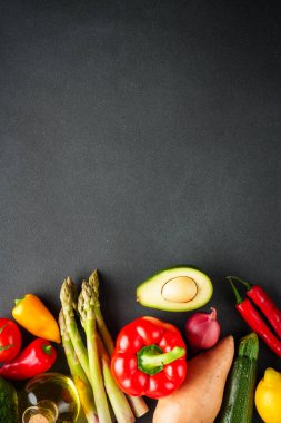 Siyah arka planda sebzeler. Paprika, kuşkonmaz, domates, brokoli ve avokado. Sağlıklı yemek, vejetaryen yemeği.