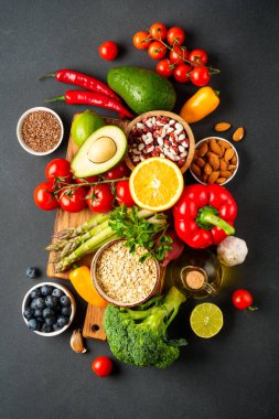 Taze sebze, fındık ve tahıllar siyah arka planda. Üst görünüm.