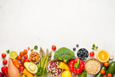 Beyaz arka planda sağlıklı yiyecekler. Taze sebze, meyve, fasulye ve fındık. Kopyalama alanı olan düz.