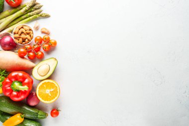 Sağlıklı yemek, vejetaryen yemeği. Beyaz arka planda taze sebzeler. Paprika, kuşkonmaz, domates, brokoli, mantar ve zeytinyağı..