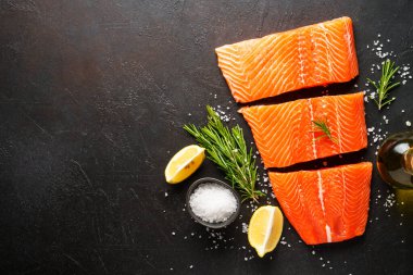 Baharatlı çiğ somon filetosu. Siyah arkaplanda kopyalama alanı olan üst görünüm.