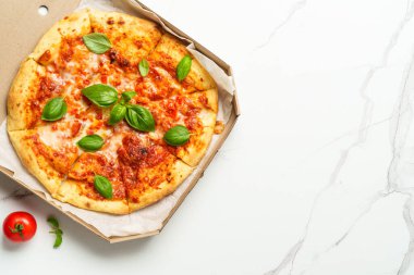 Beyaz arka planda karton bir kutuda pizza Margarita. Lezzetli öğle veya akşam yemeği, fast food.
