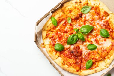 Beyaz arka planda karton bir kutuda pizza Margarita. Lezzetli öğle veya akşam yemeği, fast food.
