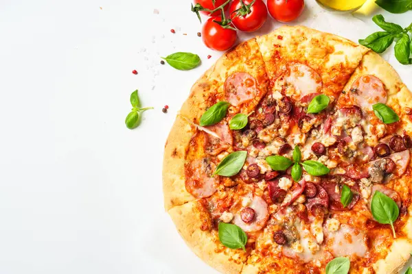 Beyaz arka planda pizza ve yemek malzemeleri. Jambonlu, salamlı ve sosisli lezzetli et pizzası. Beyaz üzerine üst görünüm.