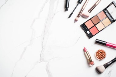 Beyaz arka planda kozmetik ürünleri uydur. Kozmetik palet, fırça, bronzlaştırıcı ve ruj. Düz yatıyordu.