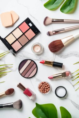 Beyaz arka planda kozmetik ürünleri. Palet, fırça ve ruj. Kopyalama alanı olan üst görünüm.