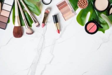 Beyaz arka planda kozmetik ürünleri. Palet, fırça ve ruj. Kopyalama alanı olan üst görünüm.