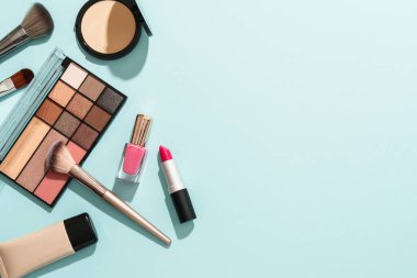 Mavi arka planda profesyonel makyaj ürünleri. Düz yatıyordu.