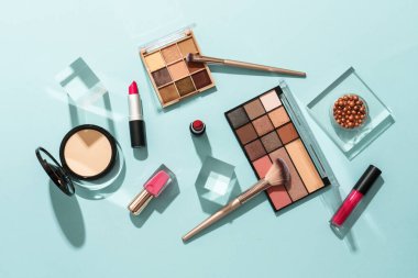 Mavi arka planda profesyonel makyaj ürünleri. Düz yatıyordu.