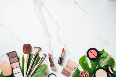 Beyaz arka planda kozmetik ürünleri. Palet, fırça ve ruj. Kopyalama alanı olan üst görünüm.