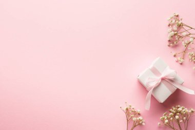 Pembe düz zemin. Beyaz çiçekli hediye kutusu..