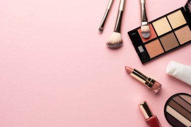 Pembe arka plandaki ürünleri uydur. Göz farı, fosforlu kalem, krem, ruj ve kozmetik fırçalar..