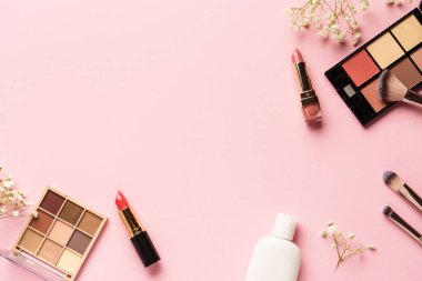 Pembe arka plandaki ürünleri uydur. Göz farı, fosforlu kalem, krem, ruj ve kozmetik fırçalar..