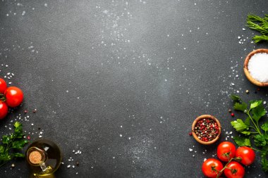 Mutfak masasında yemek malzemeleri var. Organik sebzeler, zeytinyağı, siyah bitkiler ve baharatlar..