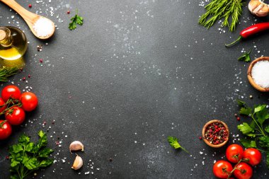 Mutfak masasında yemek malzemeleri var. Organik sebzeler, zeytinyağı, siyah bitkiler ve baharatlar..