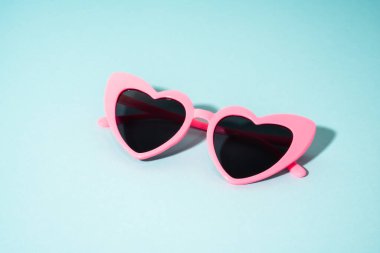 Renkli arka planda kalp şeklinde gözlük. Güneş gölgeleri.