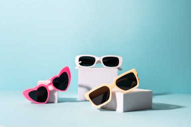 Güneşli gölgeli beyaz podyumlarda güneş gözlüğü. Yaz indirimi.