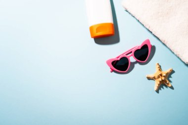 Yaz dönemi. Güneş gözlüğü, güneş kremi ve mavi gölgeli deniz kabuğu..