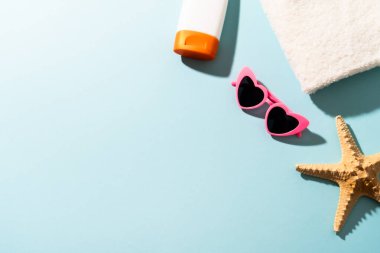 Yaz düzlüğü arka plandaydı. Güneş gözlüğü, güneş kremi ve güneşli gölgeli deniz kabuğu.
