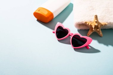 Yaz tatili konsepti. Güneş gözlüğü, güneş kremi ve güneşli gölgeli deniz kabuğu.