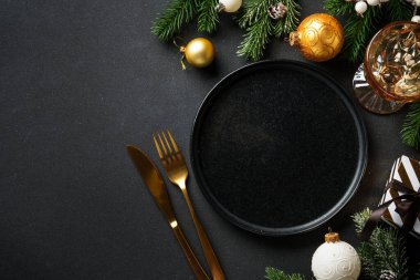 Noel sofrası kurma, yemek geçmişi. Altın Noel süslemeleri ve çatal bıçaklı el işi tabaklar. Kopyalama alanı olan düz.