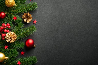Köknar ağacı ve tatil süslemeleri olan siyah Noel arkaplanı.