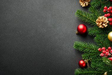 Noel arka planında köknar ağacı ve siyahların üzerinde tatil süslemeleri vardı. Tasarım için sace kopyala.