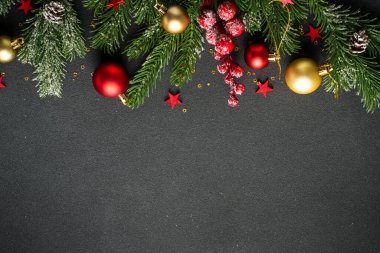 Noel arkaplanı köknar ağacı ve siyah üzerine renkli tatil süslemeleri ile yatıyordu..