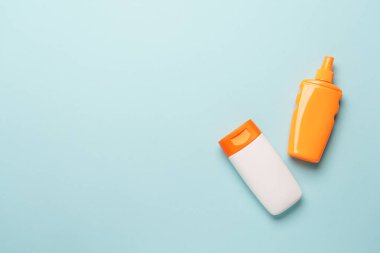 Güneş kremi, mavi arka planda. Fotokopi alanı olan düz bir yer. Güneş koruma kavramı.