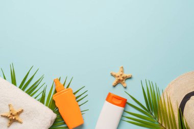 Yaz düzlüğü arka plandaydı. Güneş gözlüğü, güneş kremi, havlu ve deniz kabuğu mavi sırt grubunda.