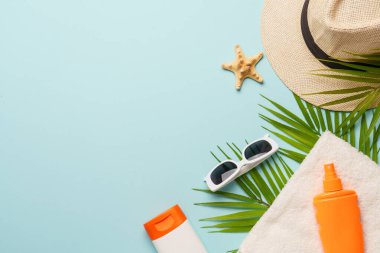 Yaz düzlüğü arka plandaydı. Mavi arka planda güneş gözlüğü, güneş kremi, havlu ve deniz kabuğu..