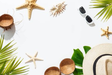 Yaz düzlüğü arka plandaydı. Palmiye yaprakları, şapka, güneş gözlükleri, beyaz arka planda deniz kabukları, güneşli gölgeler..